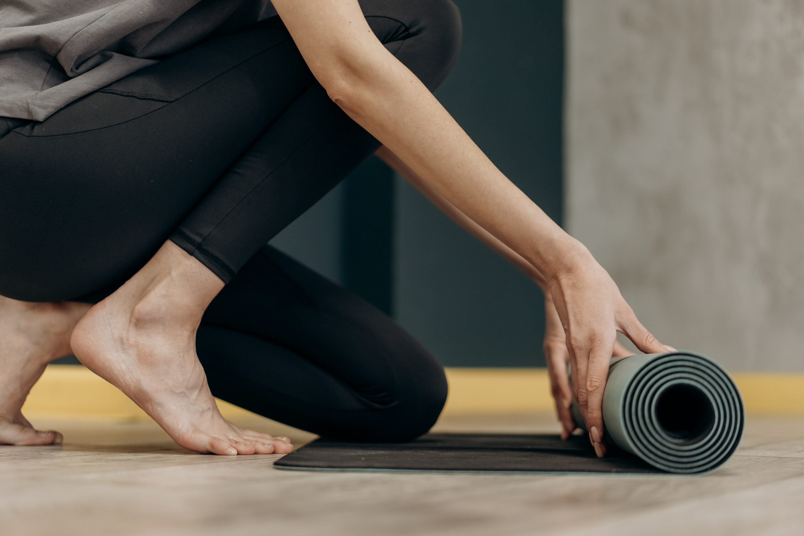 Jemand bereitet sich auf Therapie/Training Zuhause vor, indem er/sie die Matte ausrollt